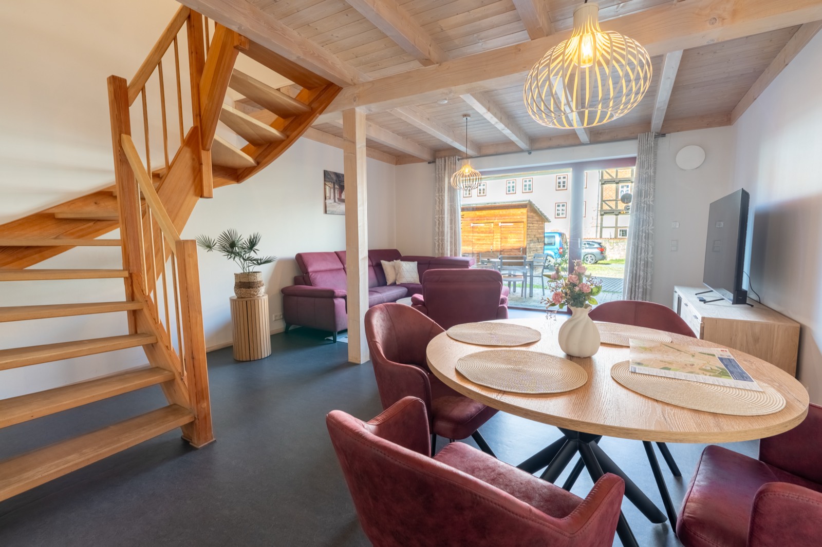 Wohn- und Essbereich mit Esstisch und Holztreppe