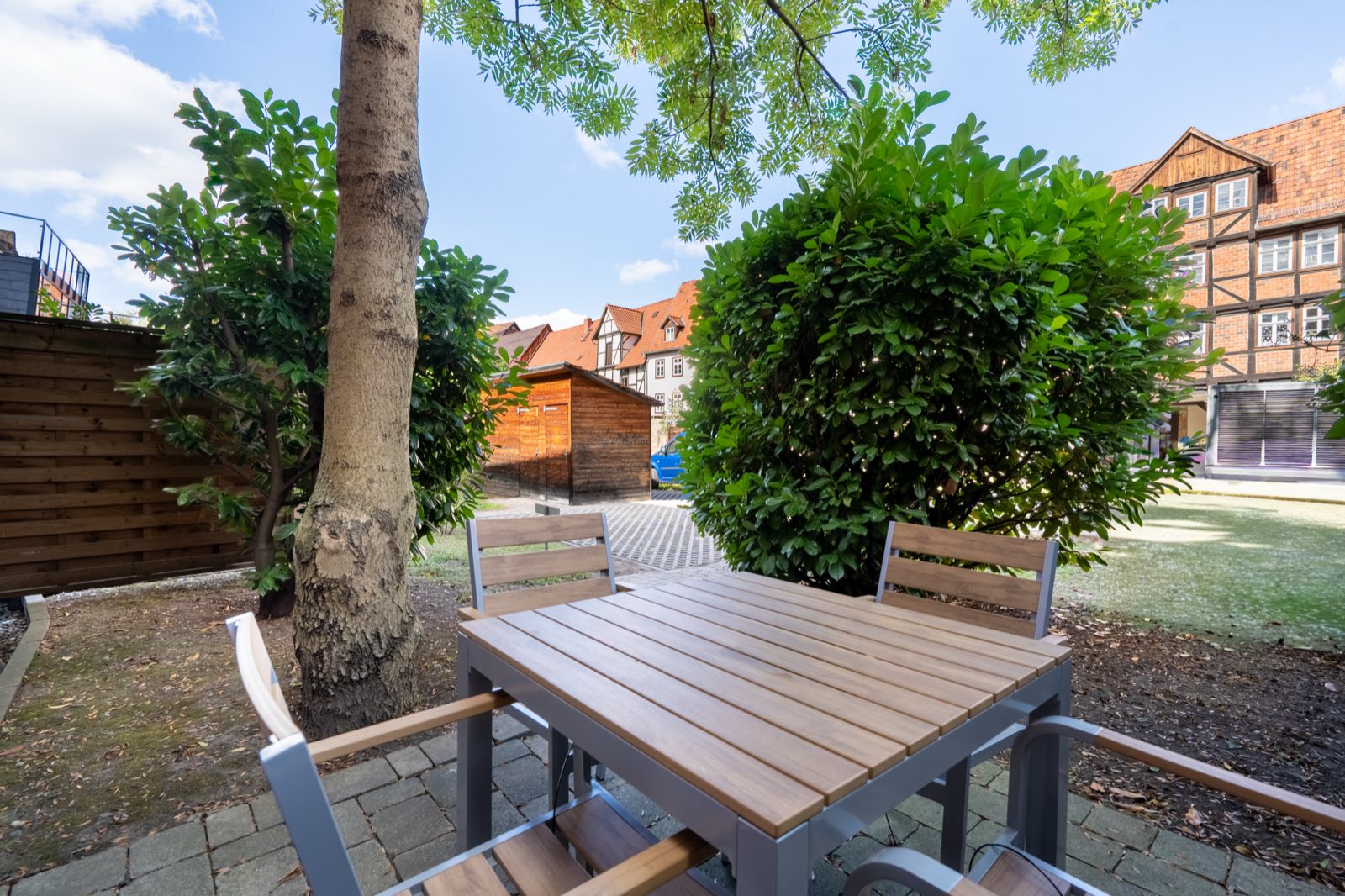Terrasse von Lodge 5 mit Gartenmöbeln unter einem Baum