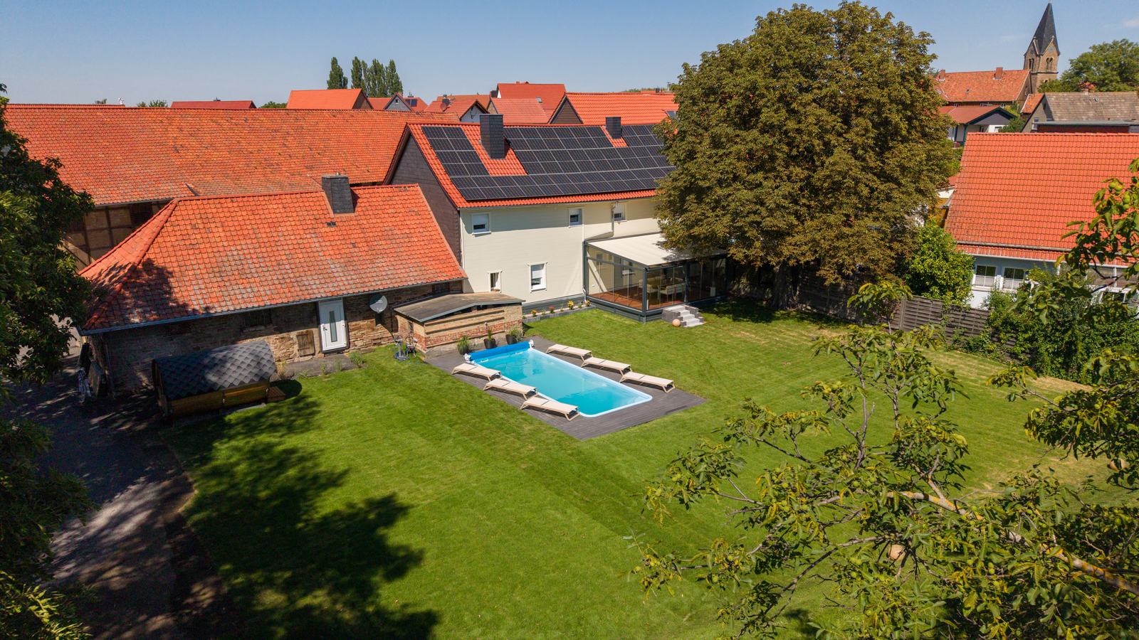 Außenanlage der Wellness Lodge Reddeber mit Pool und Sommergarten